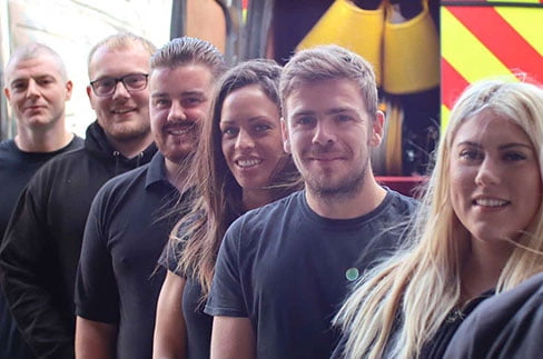 Team of Environ Property Services engineers smiling and standing in a row, showcasing expertise in drainage and property maintenance.